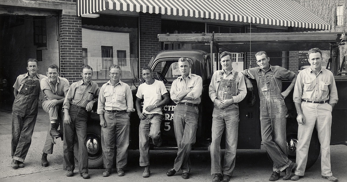 Photo: The SVEC 1940s/early 1950s line crew standing in front of the first SVEC office which was located on Elm Avenue in South Pittsburg, between 2nd and 3rd streets. Pictured left to right are: Bill Thompson, Bobby Brown, Leonard Peoples, Roy Conner, James Edward Henderson, J.R. Hookey (foreman), J.C. Blevins, Rance Castle Sr., and Riley Choate.